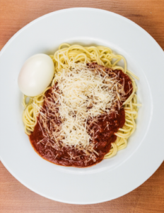 Tomatensoße mit Ei und Spaghetti im Teller